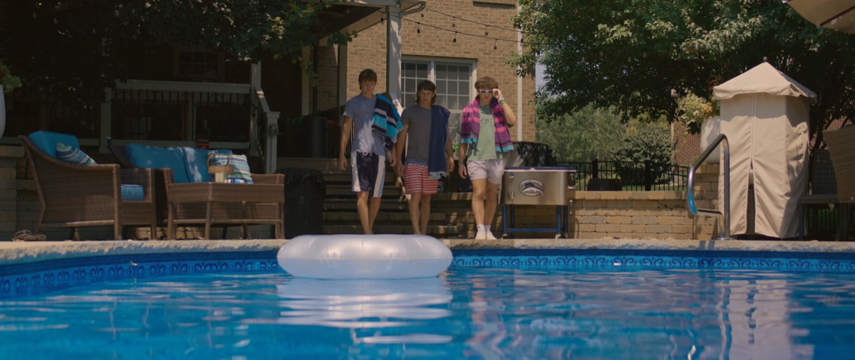 Still from Poolside Getaway — a daylit exterior portrait framed in widescreen.